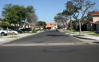Residential street with cars in driveways and on the street.